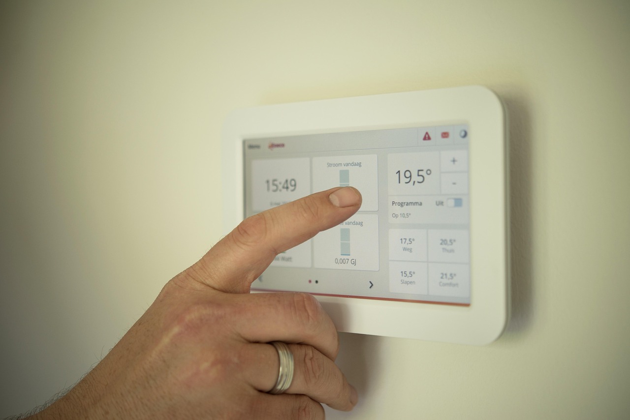 Termostato smart WiFi moderno installato su muro casa